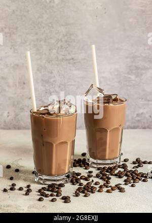 Kalter Brühkaffee mit Eiswürfeln und Milch, heller Hintergrund. Vertikale Ausrichtung, Kopierbereich. Stockfoto