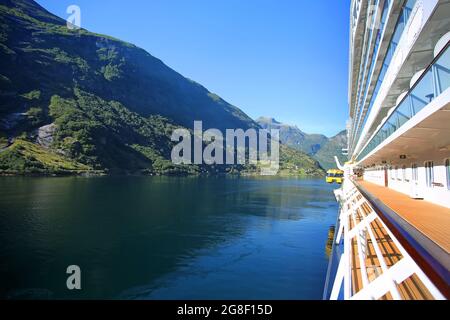 An einem schönen Sommertag senkt das Schiff den Tender ins Wasser. Spiegelungen der Berge im Fjord. Geiranger Stadt, Norwegen Stockfoto