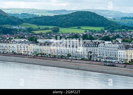 LLANDUDNO, WALES - 04. JULI 2021: Blick auf die kurvige Promenade von Llandudno, gesäumt von Hotels. Stockfoto