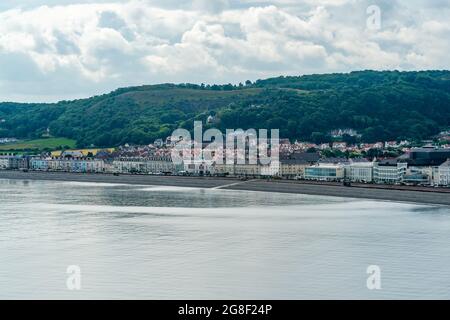 LLANDUDNO, WALES - 04. JULI 2021: Blick auf die kurvige Promenade von Llandudno, gesäumt von Hotels Stockfoto