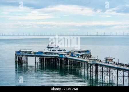 LLANDUDNO, WALES - 04. JULI 2021: Blick auf den Llandudno Pier und einen 576-Megawatt-Windpark Gwynt-y-Mor. Stockfoto