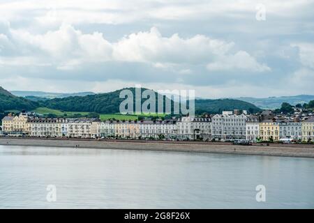 LLANDUDNO, WALES - 04. JULI 2021: Blick auf die kurvige Promenade von Llandudno, gesäumt von Hotels. Stockfoto
