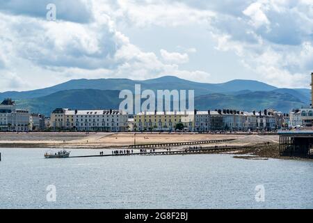 LLANDUDNO, WALES - 04. JULI 2021: Blick auf den Strand und die Promenade von Llandudno, gesäumt von Hotels. Stockfoto