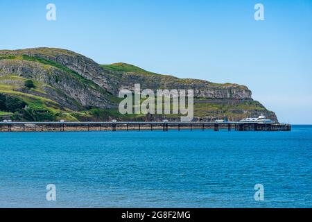 Blick auf den Llandudno Pier und Great Orme über die Bucht in Llandudno, Wales Stockfoto