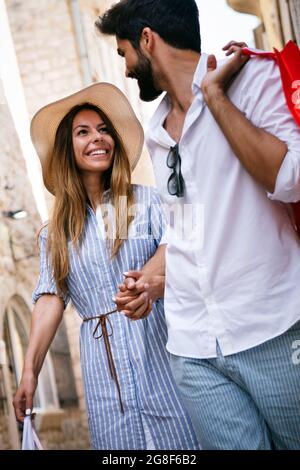 Junge glückliche Paar mit Einkaufstaschen in der Stadt genießen Sommerurlaub Stockfoto