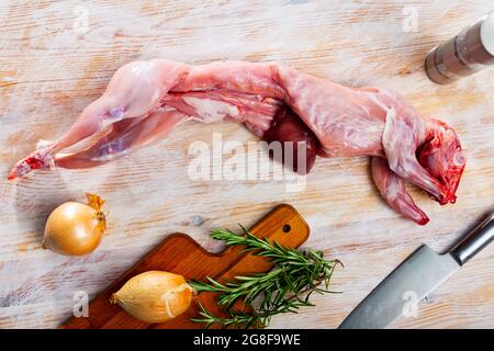 Rohes Kaninchen mit Zwiebeln und Gewürzen Stockfoto