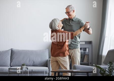 Minimales Porträt eines liebenden älteren Paares, das zu Hause zusammen tanzt, Platz kopieren Stockfoto