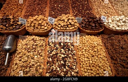 Vielfalt von Nüssen und Schokolade in Schalen in einem Markt Stockfoto