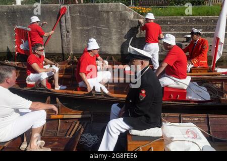 Boveney Lock, in der Nähe von Eton, Großbritannien: 20. Juli 2021. Jährliche Swan Upping Zählung der Schwanenpopulation an der Themse. Swan Uppers von der Worshipful Company of Vintners und der Worshipful Company of Dyers rudern mit dem Schwanenmarker der Königin David Barber (Scharlach-Blazer) in traditionellen Skiffs flussaufwärts. Die jährliche Veranstaltung geht vermutlich auf das Jahr 1189 zurück, als die Krone den Besitz aller stummen Schwäne für Essen für Bankette und Feste beanspruchte. Heute werden die Cygnets gewogen und gemessen, um Schätzungen der Wachstumsraten zu erhalten, und auf Anzeichen von Verletzungen untersucht, die in der Regel durch Angelhaken und Angelschnur verursacht werden. Stockfoto