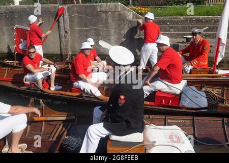 Boveney Lock, in der Nähe von Eton, Großbritannien: 20. Juli 2021. Jährliche Swan Upping Zählung der Schwanenpopulation an der Themse. Swan Uppers von der Worshipful Company of Vintners und der Worshipful Company of Dyers rudern mit dem Schwanenmarker der Königin David Barber (Scharlach-Blazer) in traditionellen Skiffs flussaufwärts. Die jährliche Veranstaltung geht vermutlich auf das Jahr 1189 zurück, als die Krone den Besitz aller stummen Schwäne für Essen für Bankette und Feste beanspruchte. Heute werden die Cygnets gewogen und gemessen, um Schätzungen der Wachstumsraten zu erhalten, und auf Anzeichen von Verletzungen untersucht, die in der Regel durch Angelhaken und Angelschnur verursacht werden. Stockfoto