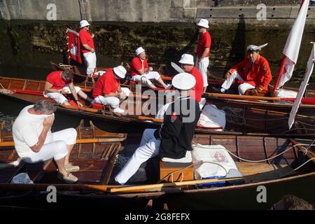 Boveney Lock, in der Nähe von Eton, Großbritannien: 20. Juli 2021. Jährliche Swan Upping Zählung der Schwanenpopulation an der Themse. Swan Uppers von der Worshipful Company of Vintners und der Worshipful Company of Dyers rudern mit dem Schwanenmarker der Königin David Barber (Scharlach-Blazer) in traditionellen Skiffs flussaufwärts. Die jährliche Veranstaltung geht vermutlich auf das Jahr 1189 zurück, als die Krone den Besitz aller stummen Schwäne für Essen für Bankette und Feste beanspruchte. Heute werden die Cygnets gewogen und gemessen, um Schätzungen der Wachstumsraten zu erhalten, und auf Anzeichen von Verletzungen untersucht, die in der Regel durch Angelhaken und Angelschnur verursacht werden. Stockfoto