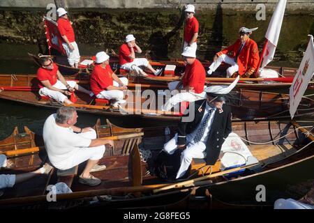 Boveney Lock, in der Nähe von Eton, Großbritannien: 20. Juli 2021. Jährliche Swan Upping Zählung der Schwanenpopulation an der Themse. Swan Uppers von der Worshipful Company of Vintners und der Worshipful Company of Dyers rudern mit dem Schwanenmarker der Königin David Barber (Scharlach-Blazer) in traditionellen Skiffs flussaufwärts. Die jährliche Veranstaltung geht vermutlich auf das Jahr 1189 zurück, als die Krone den Besitz aller stummen Schwäne für Essen für Bankette und Feste beanspruchte. Heute werden die Cygnets gewogen und gemessen, um Schätzungen der Wachstumsraten zu erhalten, und auf Anzeichen von Verletzungen untersucht, die in der Regel durch Angelhaken und Angelschnur verursacht werden. Stockfoto