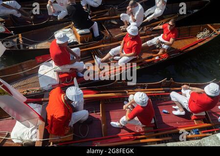 Boveney Lock, in der Nähe von Eton, Großbritannien: 20. Juli 2021. Jährliche Zählung der Schwanenpopulation an der Themse. Swan Uppers von der Worshipful Company of Vintners und der Worshipful Company of Dyers rudern mit dem Schwanenmarker der Königin David Barber (Scharlach-Blazer) in traditionellen Skiffs flussaufwärts. Die jährliche Veranstaltung geht vermutlich auf das Jahr 1189 zurück, als die Krone den Besitz aller stummen Schwäne für Essen für Bankette und Feste beanspruchte. Heute werden die Cygnets gewogen und gemessen, um Schätzungen der Wachstumsraten zu erhalten, und auf Anzeichen von Verletzungen untersucht, die in der Regel durch Angelhaken und Angelschnur verursacht werden. Stockfoto