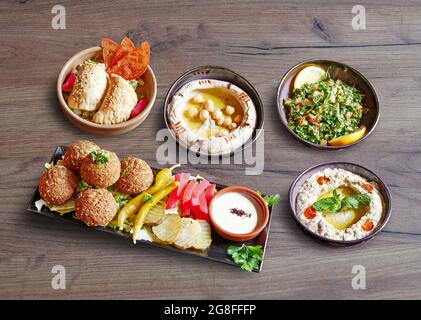 Fünf Teller und Schüsseln mit Mezze Vorspeise auf Holzboden Stockfoto
