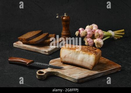 Geräuchertes Fett mit braunem Brot auf Holzschneidebrett Stockfoto