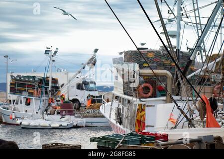 Tribunj, Kroatien - 4. Juli 2021: Kommerzielle Fischerboot-Trawler, die in der Sommerdämmerung auf einem Dock festgemacht sind Stockfoto