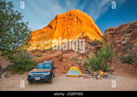 Slickrock-Formation über dem Campingplatz bei Sooner Rocks, Sunset, Hole in the Rock Road, Grand Staircase Escalante Natl Monument, Utah, USA Stockfoto