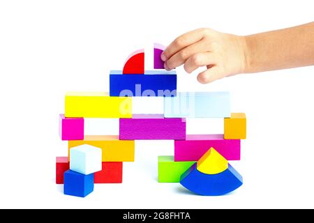 Das Kind legt farbige Würfel und sammelt Figuren. Stockfoto