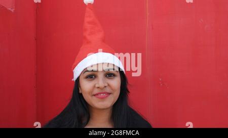 Junge indische Hündin in einem Weihnachtsmannhut im Freien Stockfoto