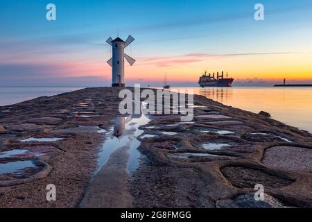 Ostsee und Stawa Mlyny, Navigationsleuchtfeuer in Form einer Windmühle bei Sonnenuntergang, offizielles Symbol von Swinoujscie, Polen Stockfoto