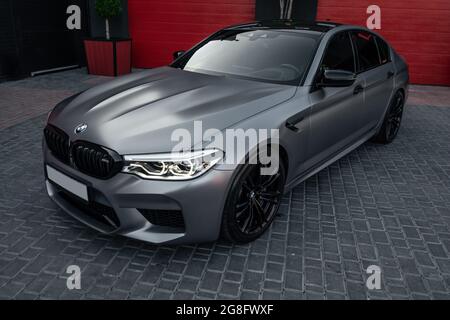 Ukraine, Odessa - 8. Juli 2021: Ein mattgrauer und schwarz umrandter Custom BMW M5 auf dem leeren Parkplatz Stockfoto