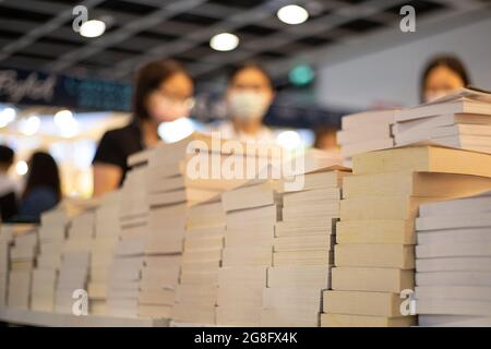 Menschen mit Gesichtsmasken lesen und kaufen Bücher auf der Hong Kong Book Fair im Hong Kong Convention and Exhibition Centre, Wan Chai während der Covid-19 Stockfoto