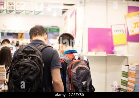 Menschen mit Gesichtsmasken lesen und kaufen Bücher auf der Hong Kong Book Fair im Hong Kong Convention and Exhibition Centre, Wan Chai während der Covid-19 Stockfoto