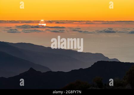 Brennender Himmel bei Sonnenuntergang über dem Atlantischen Ozean und Silhouetten von Bergen vom Pico Ruivo Gipfel, Madeira, Portugal, Atlantik, Europa Stockfoto