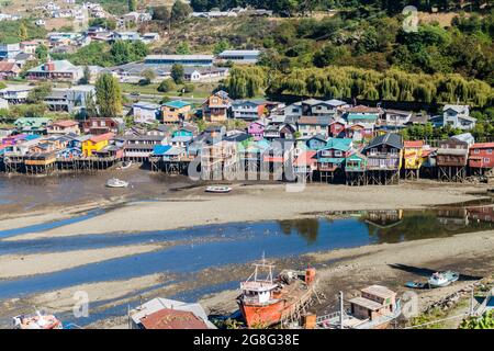 CASTRO, CHILE - 23. MÄRZ 2015: Fischerboote und Palafitos (Stelzenhäuser) bei Ebbe in Castro, Chiloe Island, Chile Stockfoto