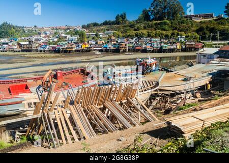 Fischerboote und Palafitos (Stelzenhäuser) bei Ebbe in Castro, Chiloe Island, Chile Stockfoto