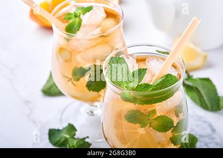 Traditioneller Eistee mit Zitrone und Eis in hohen Gläsern auf Marmortisch Hintergrund Eistee mit Zitrone. Selektiver Fokus. Erfrischung kaltes Sommergetränk Stockfoto