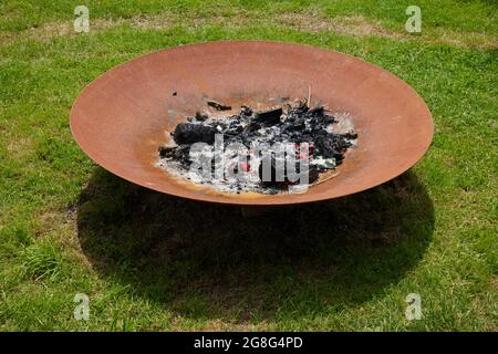 Große Metall brennende Schale draußen auf dem Rasen gesehen. Stockfoto