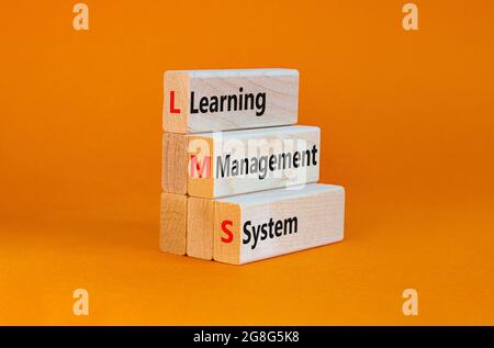 LMS, Learning Management System Symbol. Holzblöcke mit den Worten „LMS, Learning Management System“. Schöner orangefarbener Hintergrund, Kopierbereich. Geschäftlich, Stockfoto