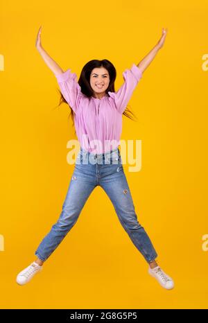 Ein Konzept der „„„„„„ In voller Länge Porträt auf positive armenische Frau springen und täuschen auf gelbem Hintergrund, Ernte Stockfoto