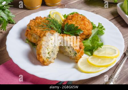 Gebratene Krazy Fleischschnitzel gefüllt mit Eiern und Kräutern auf einem weißen Teller close-up Stockfoto