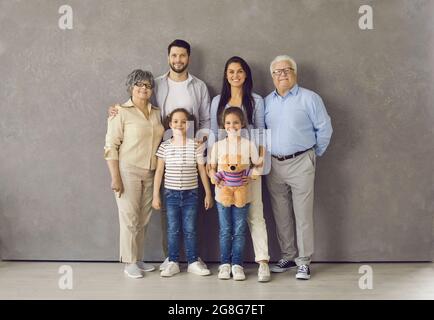 Studioporträt einer glücklichen, mehrgenerationsübergreifenden Familie, die zusammen steht und lächelt Stockfoto