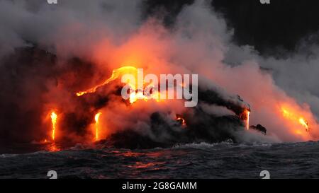 Lava, die durch den Vulkanausbruch auf Big Island Hawaii im Ozean fließt. Von der Lava-Bootstour aus gesehen. Lava aus dem Vulkan Kilauea von Hawaii Vulkanen Stockfoto