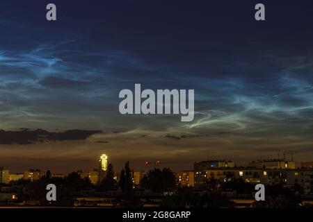 Nächtliche Wolke (NLC, Nachtwolken) über Wohnprojekt und Kirche am Abend. Wolkenähnliche Phänomene in der Mesosphäre. Es sind die höchsten Wolken in E Stockfoto