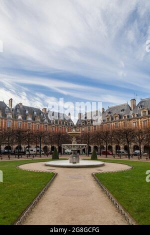 Der Place des Vosges, der älteste geplante Platz in Paris, gesäumt von Bäumen und roten Ziegelhäusern, wurde 1612 von Henri IV. Erbaut Stockfoto