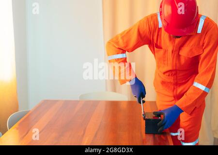 Afroamerikanischer Mechaniker, der an einem Haus arbeitet Stockfoto