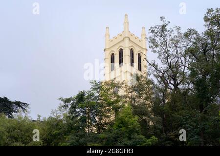 Christchurch, ex-kolonial, und Glockenturm, flankiert von Bäumen unter bewölktem Himmel im Sommer in Shimla, Himachal Pradesh, Indien. Stockfoto