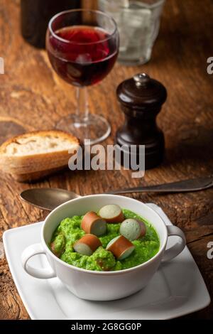 Cremige Erbsensuppe auf dunklem Holz Stockfoto