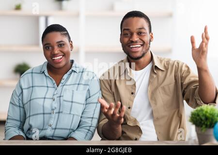 Fröhliches Afrikanisches Familienpaar Im Gespräch Mit Der Kamera Online-Kommunikation Im Haus Stockfoto