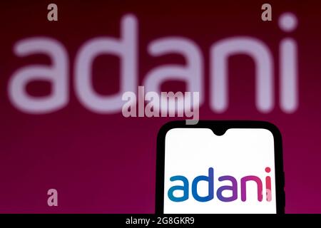 In dieser Abbildung ist das Logo der Adani Group auf einem Smartphone-Bildschirm und im Hintergrund zu sehen. Stockfoto