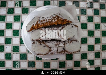 Sizilianische Cannoli, berühmte traditionelle Backwaren mit reinem Schafskäse, Zucker und Pistazien in einer knusprigen, röhrenförmigen Schale.typisch hausgemacht Stockfoto