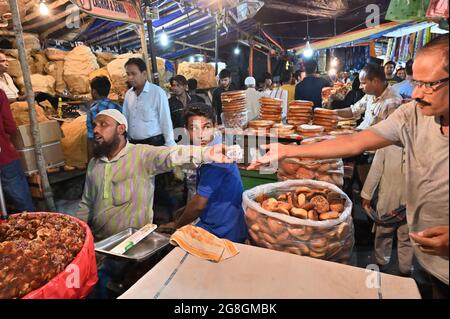 KOLKATA, WESTBENGALEN, INDIEN - MAI 27 2019 : muslimischer Verkäufer, der mit dem Käufer Geld für den Verkauf von Sevai, Dattobst, Keksen und verschiedenen Frischgrößen einkauft Stockfoto