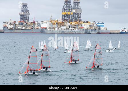 Kleines Segelschiff in der Nähe von Bohrschiffen. Stockfoto