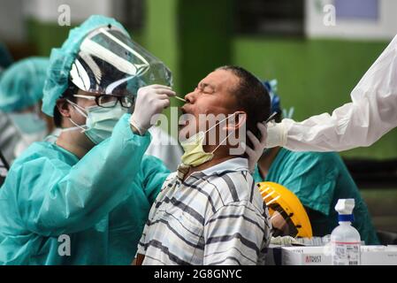 Ein Gesundheitsmitarbeiter nimmt während der Covid-19-Tests eine Probe eines Nasenabstrichs von einem Mann. Das taiwanesische CDC kündigte neue Leitlinien zur Lockerung der Pandemiebeschränkungen an. Stockfoto