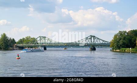 Die Glienicker Brücke über die Havel zwischen Potsdam und Berlin. Im Vordergrund ein Ausflugsboot mit Touristen. Stockfoto