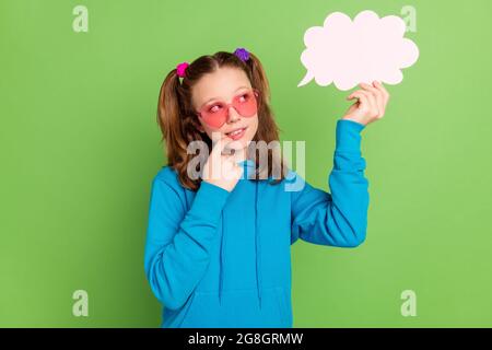 Foto von gesinnten jungen nachdenklichen Mädchen aussehen halten Hand Wolke Blase gesinnt isoliert auf grünem Hintergrund Stockfoto